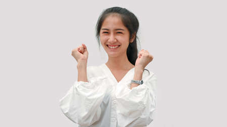 Portrait of a excited female smiling and celebrating isolated in white backgroundの写真素材