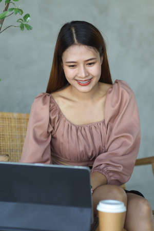 Portrait of female worker smiling while working with digital tablet in cafeの写真素材