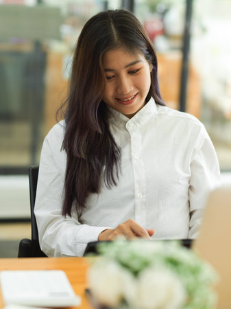 Portrait of female worker concentrate on her work with digital tablet while working in cafeの写真素材