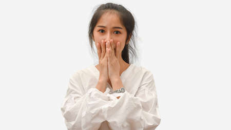 Half-length portrait of young female feeling amaze in white shirt isolated in white backgroundの写真素材