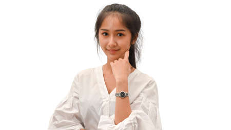 Half-length portrait of young female in white shirt smiling to camera isolated in white backgroundの写真素材