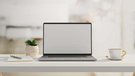 Computer laptop with mock-up screen on white table with stationery, cup and plant pot, 3D rendering, 3D illustrationの写真素材