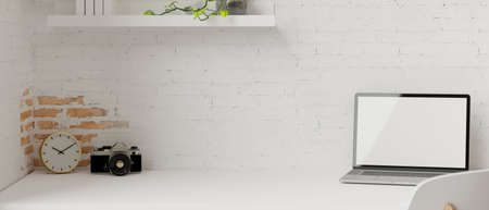 Laptop with mock-up screen in minimal workspace with camera, clock and brick wall, 3D rendering, 3D illustrationの写真素材