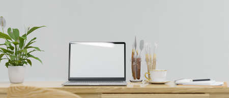 Working space with laptop, craft supplies, paint tools and plant pot on the table, 3D rendering, 3D illustrationの写真素材