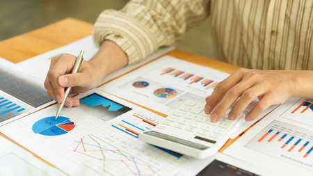 Close up view of businesswoman hands working with calculator and business paperworkの写真素材
