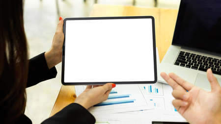 Close up view of businesspeople discussing on their project and using digital tablet with mock-up screenの写真素材
