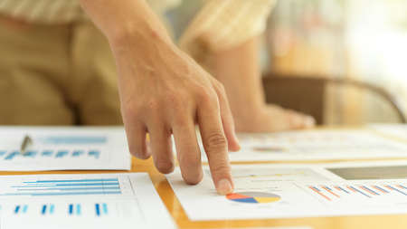 Close up view of businessperson index finger pointing on the chart on business paperworkの写真素材