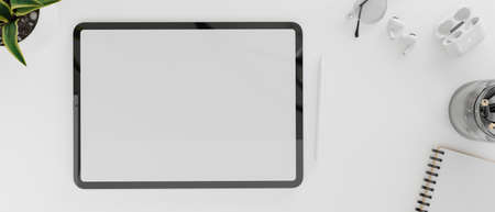 Top view of digital tablet with mock-up screen on white concept workspace with stationeryの写真素材