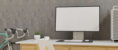 Computer monitor with mock-up screen on the desk in home office with bicycleの写真素材