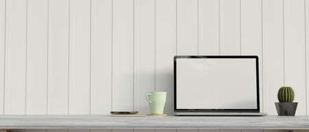 Computer laptop with mock-up screen on the desk with stuff, cactus pot and mug, 3D rendering, 3D illustrationの写真素材