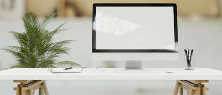 Desktop computer with mock-up screen on white desk in simple office room, 3D rendering, 3D illustrationの写真素材