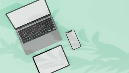Digital devices with laptop, tablet and smartphone with mock-up screen isolated on mint green background, 3D rendering, 3D illustration, top viewの写真素材