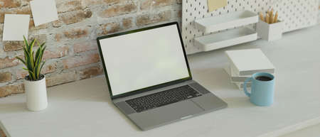 Minimal workspace with laptop, stationery on the desk and shelf on loft wall, copy space, 3D rendering, 3D illustrationの写真素材