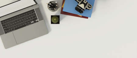 Top view of modern office desk with laptop, stationery, camera, decorations and copy space on white desk, 3D rendering, 3D illustrationの写真素材