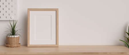 Mock-up wooden frame with copy space for product display on wooden table decorated with plants and white wallpaper, 3D rendering, 3D illustrationの写真素材