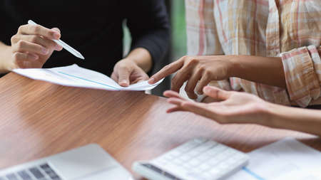 Close-up group of business team discussing their financial profit in meeting roomの写真素材