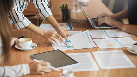 Close-up of team work brainstorming their project budget in the meeting with project budget reports,...