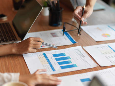 Close up of financial team consulting about loan comparison for company in the meeting room with loan comparison report, laptop and office suppliesの写真素材