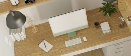 Top view of modern working space designed with computer monitor mock-up, office supplies and decorations on the wooden table. 3D rendering, 3D illustrationの写真素材