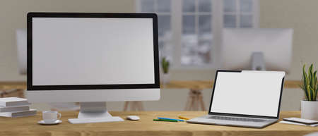 Working space mock-up concept, Empty computer monitor and laptop screen on the wooden table with office supplies and decorations in blurry interior in the background, 3D rendering, 3D illustrationの写真素材