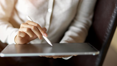 Close up of businesswoman hand working on tablet with stylus, suite for business or study contentの写真素材