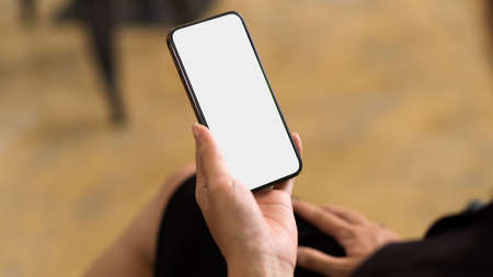 Smartphone with empty screen with blurred background, close up brand advertising via mobile phone, female reading text book on smartphoneの写真素材