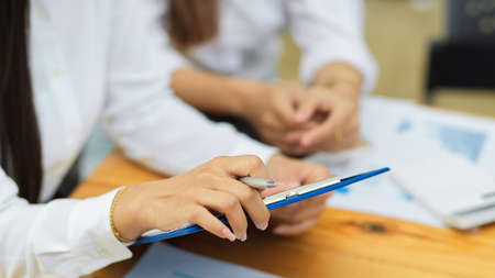 Cropped shot of business crew looking and analysing business plan, financial report together at the officeの写真素材