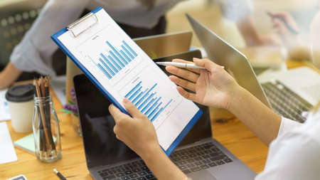 Businesswoman showing financial report to her colleague at officeの写真素材