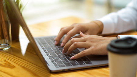 Cropped shot of college student doing work assignment via smart laptop at co-working space, female using laptopの写真素材