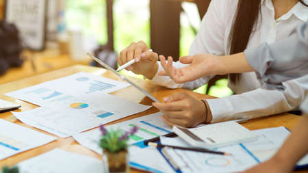 Accountant manager explain job assignment to her new intern with financial papers at meeting roomの写真素材