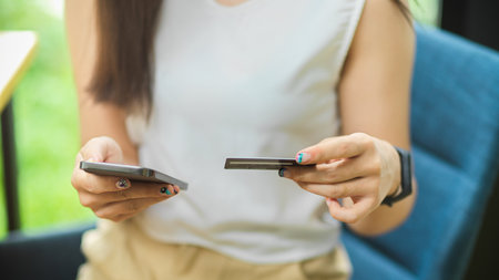 Online payments concept, female transferring money to pay on online via mobile phone while hold credit card, Cashless societyの写真素材