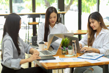 Marketing team focus on their work, work on laptop, business team working at co-working space togetherの写真素材