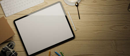Tablet empty screen mock up and copy space on wooden table background with camera, keyboard and...