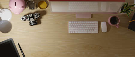 Top view, wooden work table with pink computer, camera, graphic tablet, mug, piggy bank under light, 3d rendering, 3d illustrationの写真素材