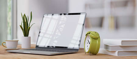 Side view, close up, Home office with laptop screen mockup, alarm clock, small plant in pot, coffee cup, books on minimal wood table, blurred room background, 3d rendering, 3d illustrationの写真素材