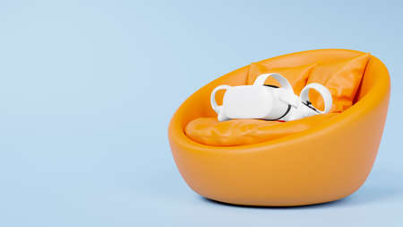 Virtual reality headset with joystick on orange comfy round chair, round leather sofa in baby blue background with copy space, 3d rendering, 3d illustrationの写真素材