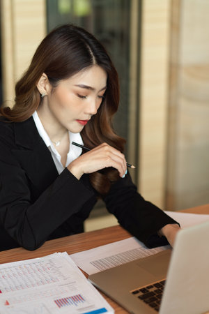 Businesswoman focus on company loan payment, working on laptop and bill invoice at office, attractive financial workerの写真素材