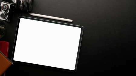 Overhead, graphic tablet white screen mockup on black background with camera, decor and copy spaceの写真素材
