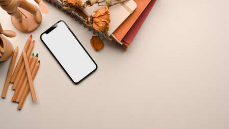 Minimal workspace in beige background concept, smartphone mockup, dry flowers, pencils, planner book, copy space for your brands of text, top view, flat layの写真素材