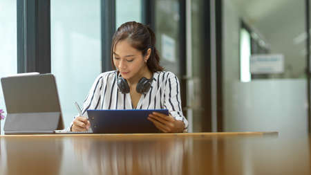 New business female employee learning on online training program, working at office, taking notesの写真素材