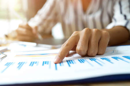 Close up image, business female pointing finger on financial data papers, working in office, managing dataの写真素材