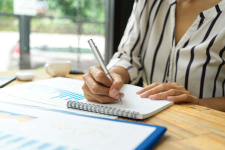 Businesswoman taking notes, importance working list on notepads at cafe, work in coffee breakの写真素材