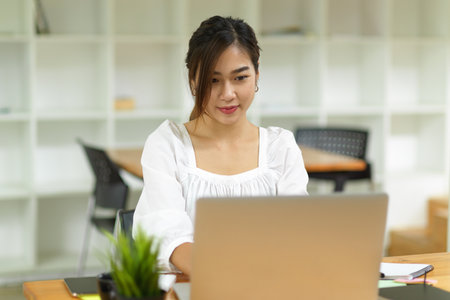 Beautiful female freelance auditor working with laptop at coffee shopの写真素材