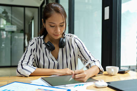 Hipster girl, graphic college student sketching new model on digital tablet in co-working space at cafeの写真素材