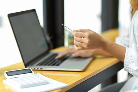 Side view, close up hands, holding credit card and using laptop, internet banking, online shopping