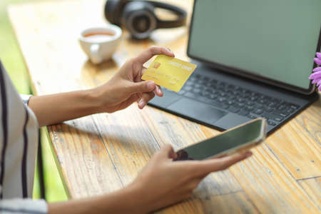 Online banking, cashless concept, woman holding credit card and mobile smartphone for pay online shoppingの写真素材