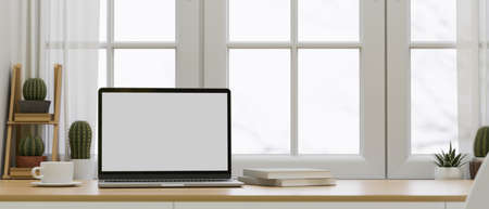 Closeup, Comfortable, minimal workspace interior design, opened laptop screen mockup on wood table near window, cactus shelf, Scandinavian house, 3d rendering, 3d illustrationの写真素材
