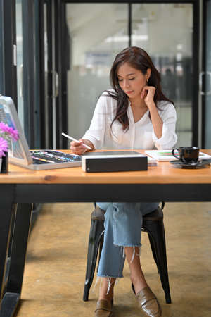 Creative designer woman sit and work with graphic tablet, artwork, painting colour on table at design studioの写真素材