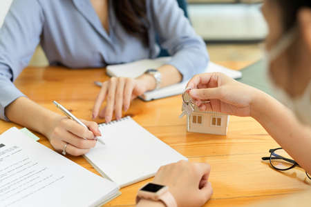 Real estate female broker making purchasing house contract with new landlord , notepad blank sheetの写真素材