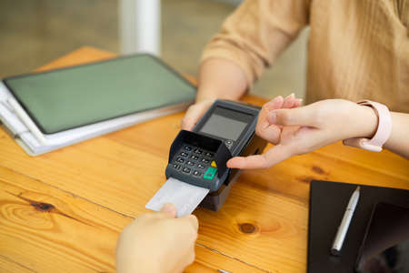 Customer paying by credit card, insert credit card into payment machine, POS terminalの写真素材